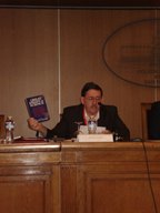 Antonio Colombo speaking about Jaki and Chesterton. The book shown prompted Father Jaki to write the book <I>Chesterton: A Seer of Science</I>
