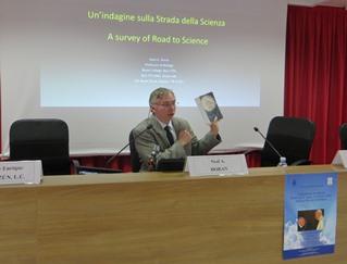 Neal Doran showing the book The Road of Science and the Ways to God that is dealt with in his intervention.